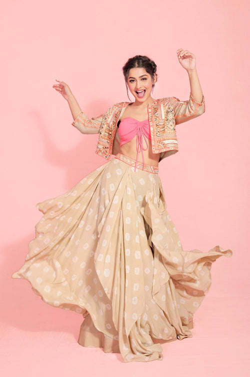 TALEISHA : Banjara cropped jacket, hand embroidered with mirrors, silk threads in tribal motifs with shell tassels. Paired along with our hand tied and dyed Handkerchief style lehenga and a versatile hot pink bandeau